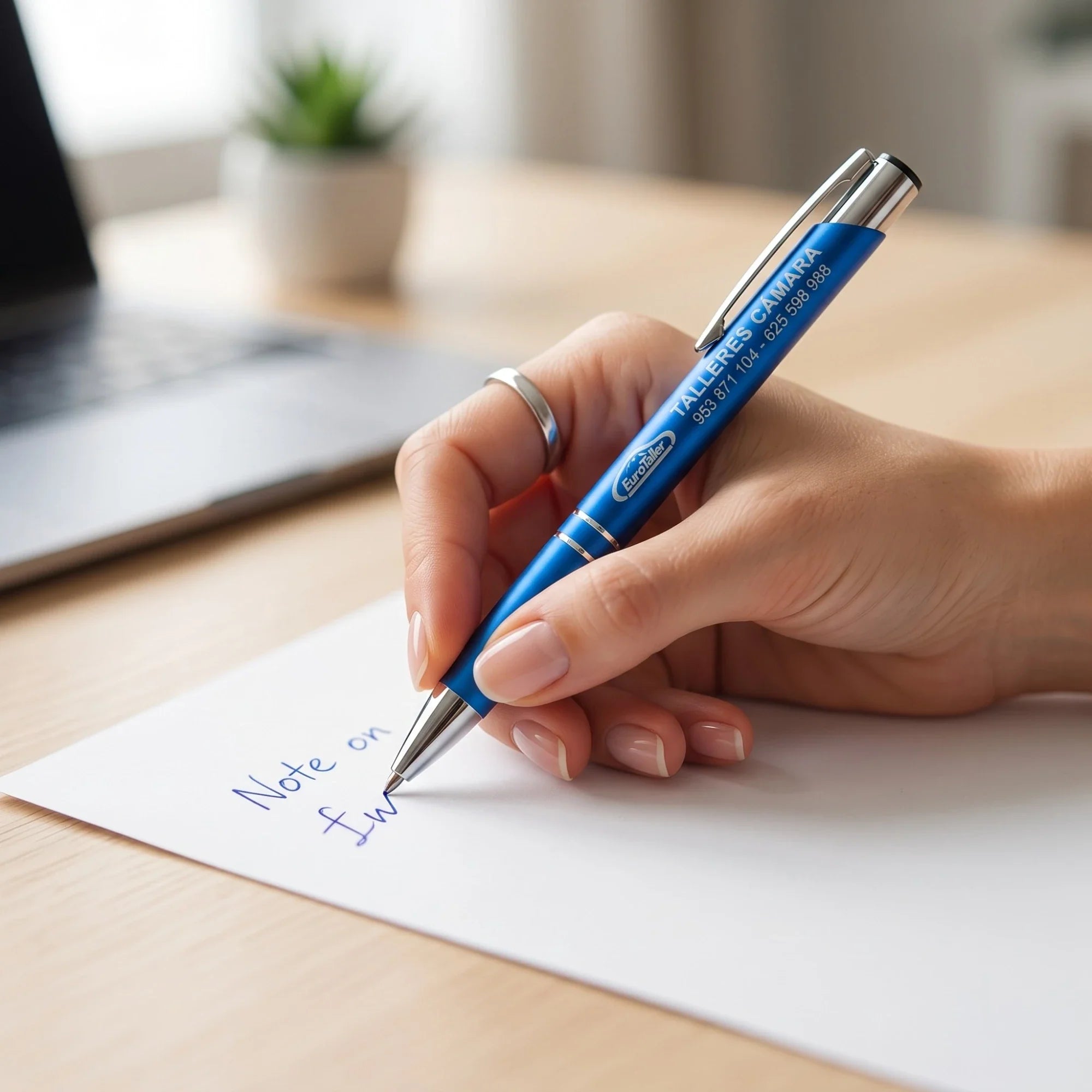 Bolígrafo personalizado con grabado láser escribiendo en tinta azul